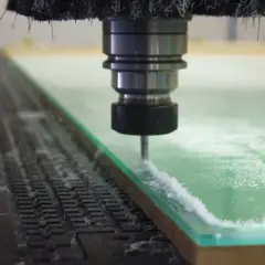 Precyzyjne frezowanie plexi przez maszynę CNC. Wióry unoszą się podczas cięcia.