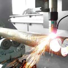 Precyzyjne wycinanie plazmą metalowej rury. Iskry sypią się podczas cięcia.