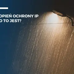 Latarnia uliczna świeci w deszczu. Tekst: "Stopień ochrony IP - co to jest?". IP44 oznacza ochronę przed bryzgami wody.