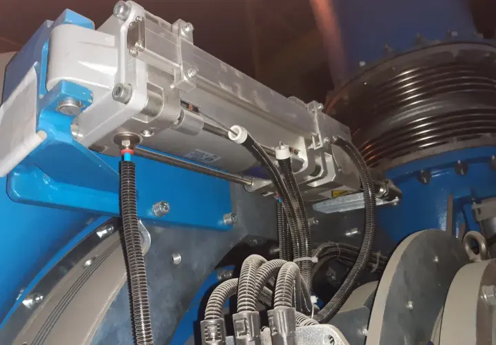 Szczegółowy widok mechanizmu z napędami pneumatycznymi, przewodami i elementami montażowymi.