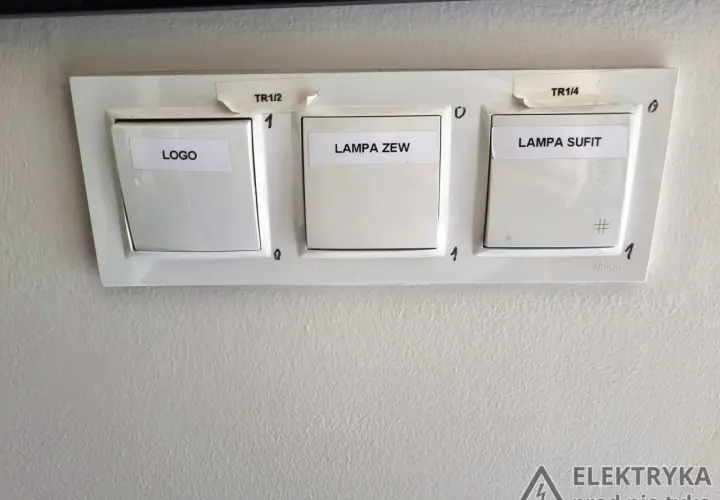 Trzy włączniki światła: LOGO, LAMPA ZEW, LAMPA SUFIT. Na górze oznaczenia TR1/2 i TR1/4. Włączniki to proste przełączniki on/off.