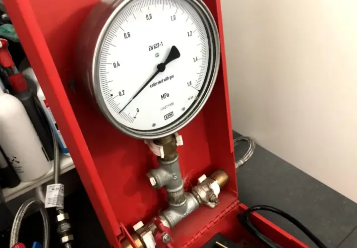 Próba szczelności instalacji wodnej powietrzem. Manometr wskazuje ciśnienie.